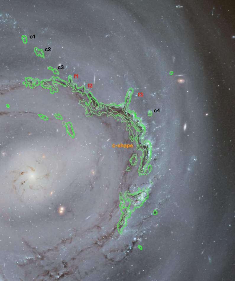 Зображення галактики з телескопа «Габбл», на який наклали отримані ALMA дані. Позначки c1, c2, c3 і c4 вказують на потоки оксиду вуглецю, а f1, f2 и f3 — хвости газу, що поверталися у галактику. Cramer, W. J. et al. / NASA / ESA / Kem Cook (LLNL)
