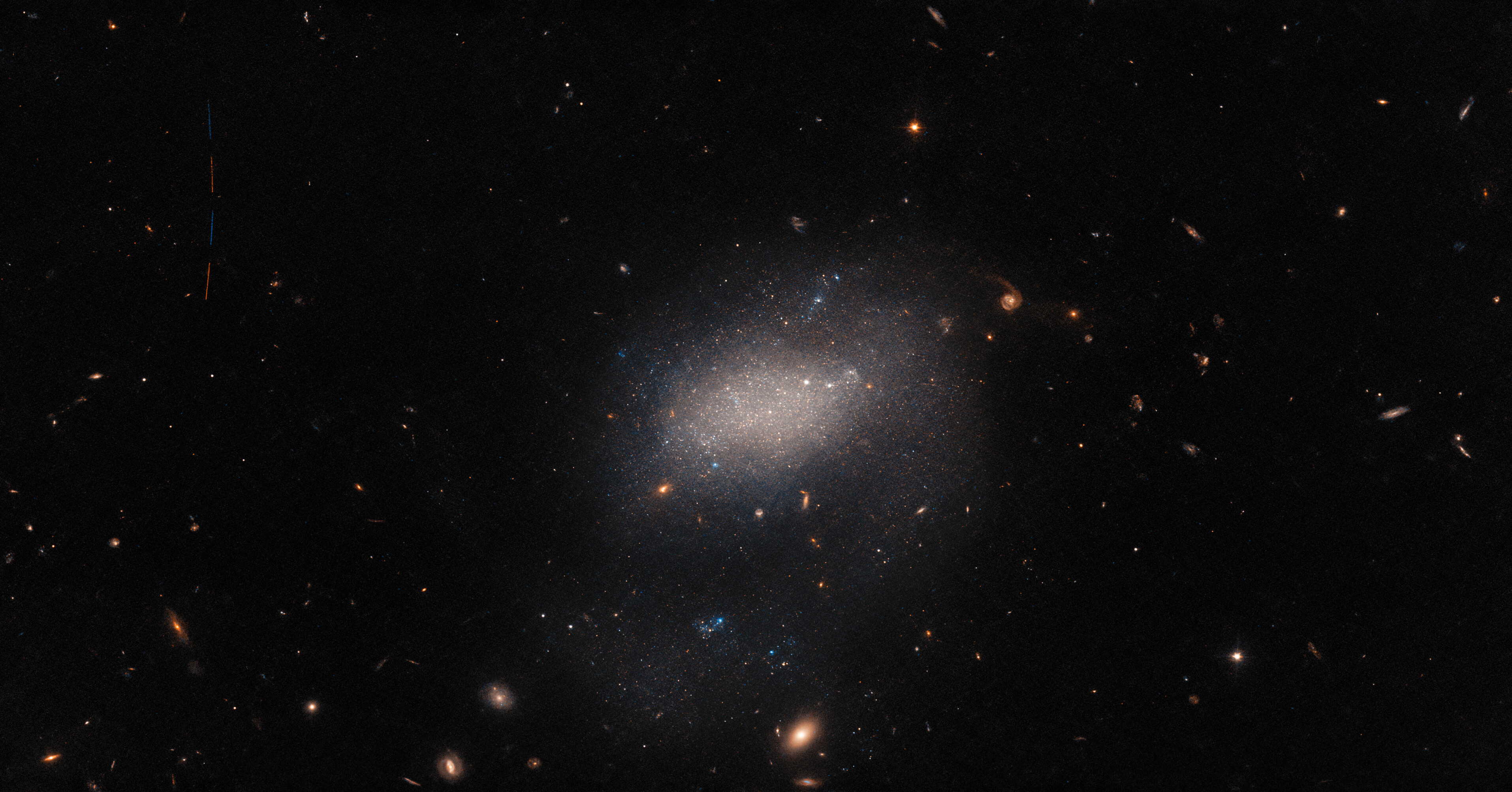 Ціль телескопа&amp;nbsp;— галактика&amp;nbsp;UGC 7983&amp;nbsp;— знаходиться у центрі світлини. Проліт астероїда ж можна роздивитися у лівому верхньому куті.&amp;nbsp;ESA / Hubble &amp;amp; NASA, R. Tully