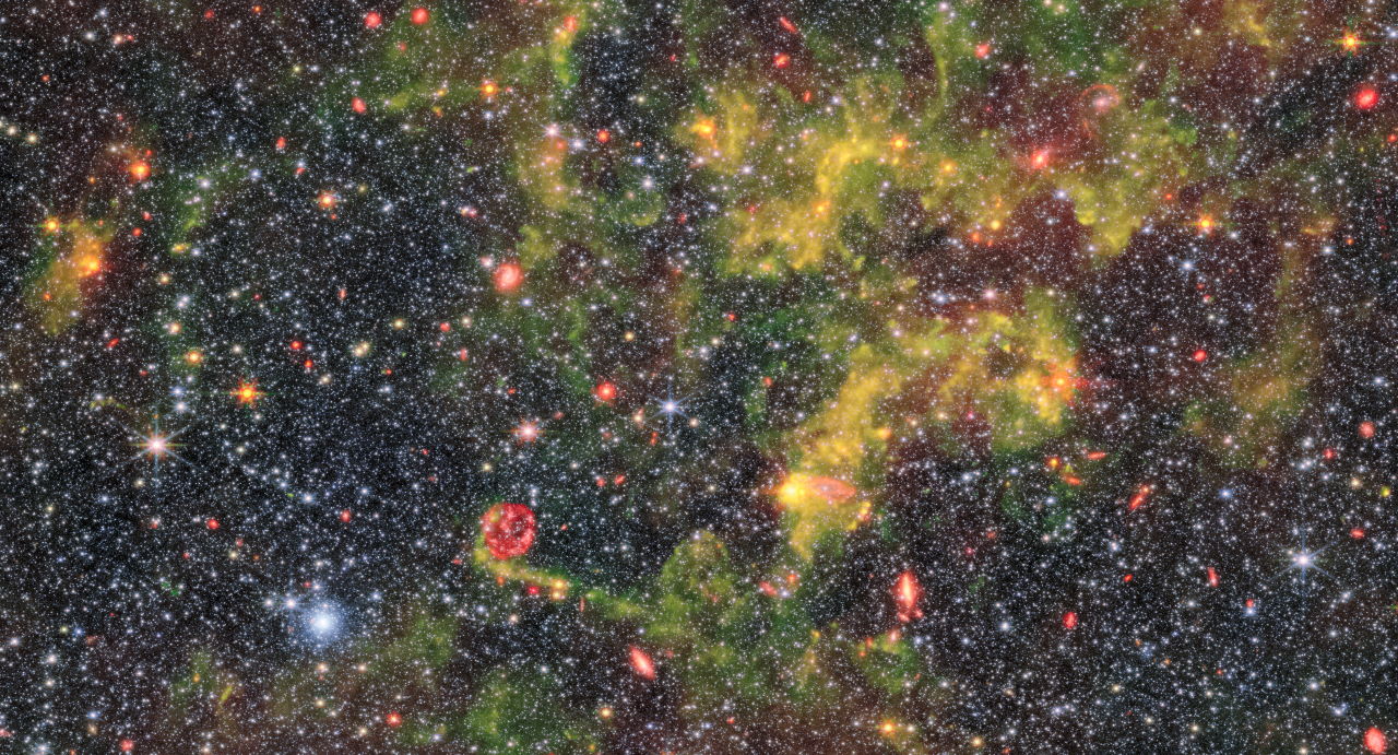Зображення галактики Барнарда, створене об'єднанням знімків, які телескоп отримав за допомогою інструментів NIRCam і MIRI. Зеленим і жовтим позначено газ і пил, червонуватим&amp;nbsp;—області зореутворення, а помаранчевим&amp;nbsp;— далекі фонові галактики.&amp;nbsp;ESA / Webb, NASA &amp;amp; CSA, M. Meixner
