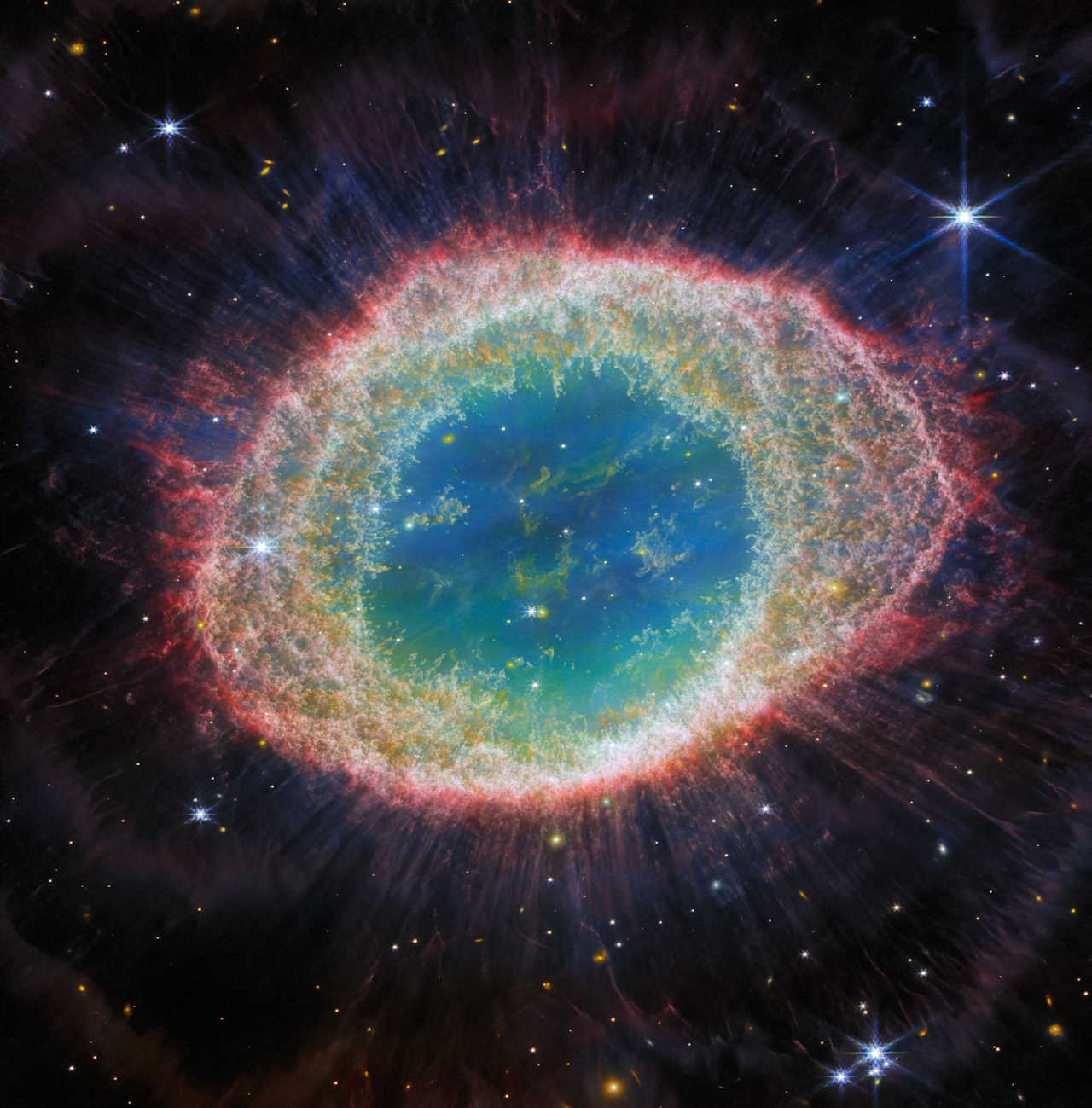 Ближньоінфрачервона камера JWST захопила Кільцеву туманність з безпрецедентною деталізацією. Цей астрономічний об'єкт у формі пончика, утворений зіркою, що викидає свої зовнішні шари, коли в неї закінчується паливо, знаходиться приблизно за 770 парсеків (2500 світлових років) від Землі в сузір'ї Ліри. Зображення демонструє складні деталі структури кілець туманності (пофарбовані рожевим і помаранчевим кольорами), які складаються з гарячих газів.