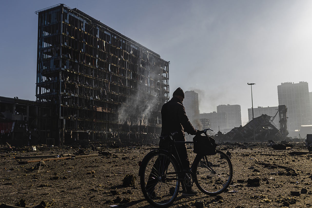 Чоловік з велосипедом йде по  по завалах торгового центру «Ретровіль»‎, зруйнованого після російського артилерійського обстрілу 20 березня 2022 року.&amp;nbsp;Alejandro Martinez Velez